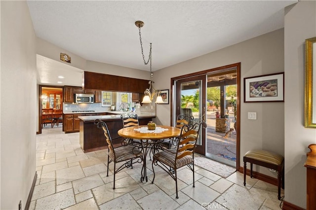 dining area with baseboards and stone tile flooring