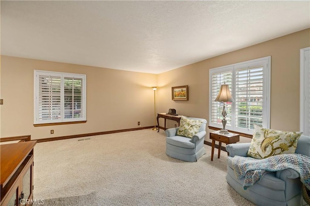 living area featuring carpet floors, baseboards, and visible vents