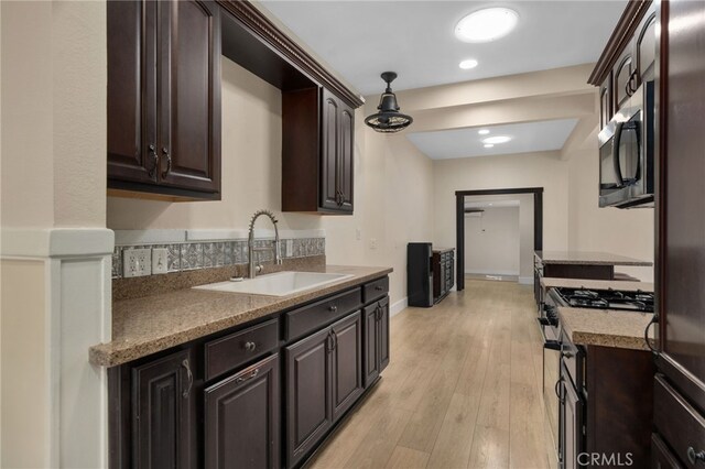 405 E Colton Ave, Redlands, CA 92374 - kitchen with dark brown cabinetry, appliances with stainless steel finishes, light wood-type flooring, a sink, and light countertops