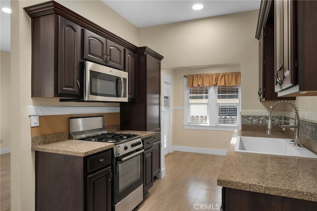 405 E Colton Ave, Redlands, CA 92374 - kitchen with a sink, dark brown cabinetry, stainless steel appliances, and light wood-style flooring