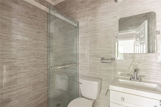 full bathroom with toilet, tile walls, a shower stall, and vanity