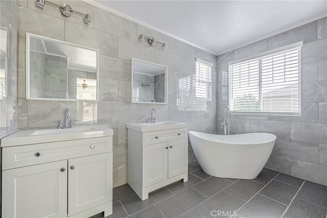 full bath with a sink, a soaking tub, a tile shower, and tile walls