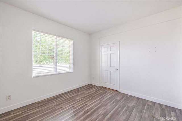 empty room featuring baseboards and wood finished floors