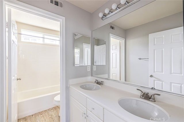 bathroom featuring toilet, visible vents, and a sink