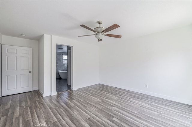 unfurnished bedroom with baseboards, a ceiling fan, wood finished floors, and connected bathroom