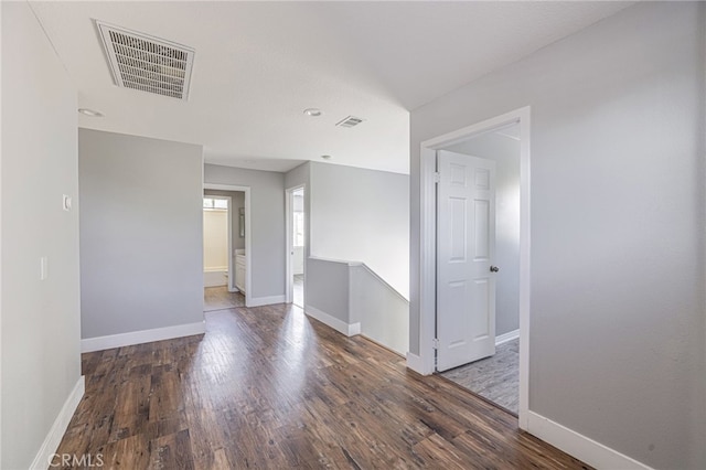 empty room with baseboards, recessed lighting, wood finished floors, and visible vents