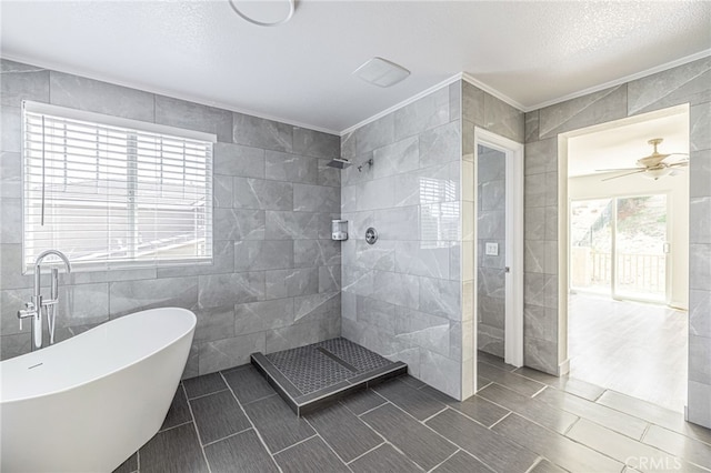 full bathroom with a ceiling fan, crown molding, tile walls, a freestanding bath, and a tile shower