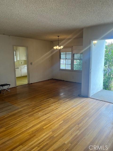 5548 Carley Ave, Whittier, CA 90601 - empty room featuring a chandelier, wood finished floors, and a textured ceiling