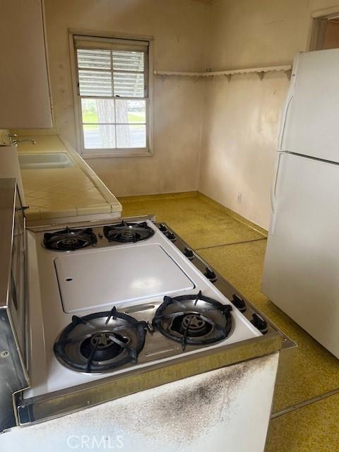5548 Carley Ave, Whittier, CA 90601 - kitchen featuring freestanding refrigerator, a sink, cooktop, and light countertops