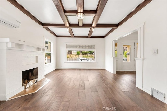 unfurnished living room featuring visible vents, plenty of natural light, and hardwood / wood-style flooring