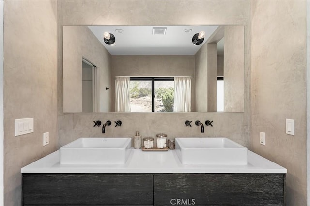 full bathroom featuring a sink, double vanity, and visible vents