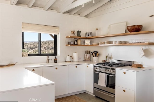 48575 Paradise Ave, Morongo Valley, CA 92256 - kitchen with stainless steel gas range oven, a sink, beamed ceiling, open shelves, and light countertops