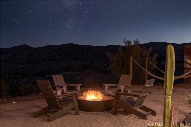 48575 Paradise Ave, Morongo Valley, CA 92256 - patio at night with an outdoor fire pit and a mountain view