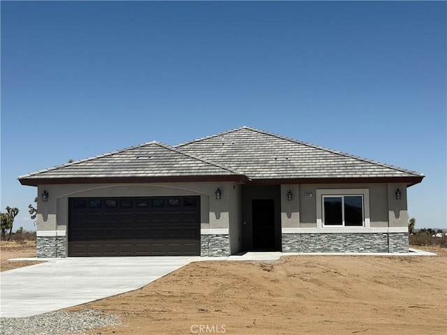 6472 Cayucos Dr, Phelan, CA 92371 - view of front of property featuring stone siding, driveway, stucco siding, and a garage