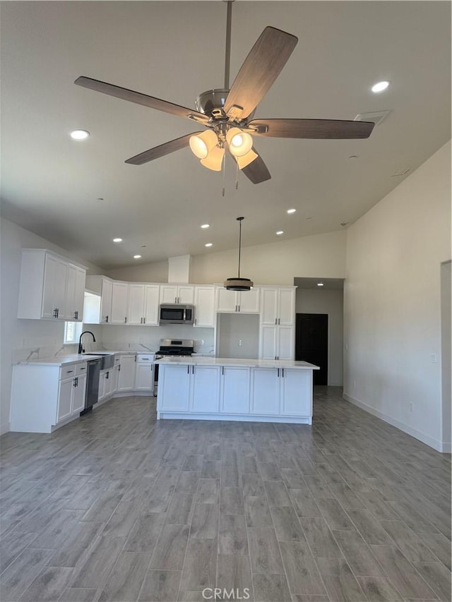 6472 Cayucos Dr, Phelan, CA 92371 - kitchen with stainless steel appliances, lofted ceiling, light wood-type flooring, open floor plan, and a ceiling fan