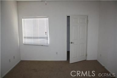 unfurnished bedroom with carpet flooring and multiple windows