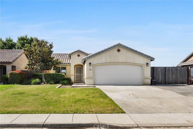 mediterranean / spanish house with an attached garage, stucco siding, a front yard, and concrete driveway