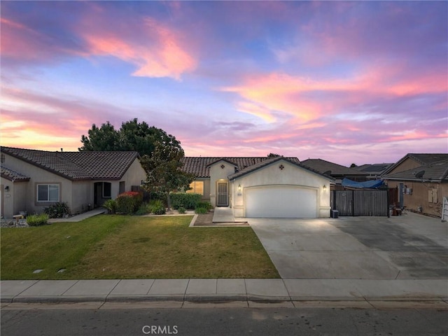 ranch-style home with an attached garage, a lawn, stucco siding, and concrete driveway