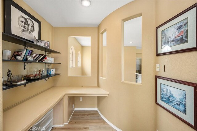 833 W Orange Heights Ln, Corona, CA 92882 - unfurnished office featuring built in desk, light wood-style floors, and baseboards