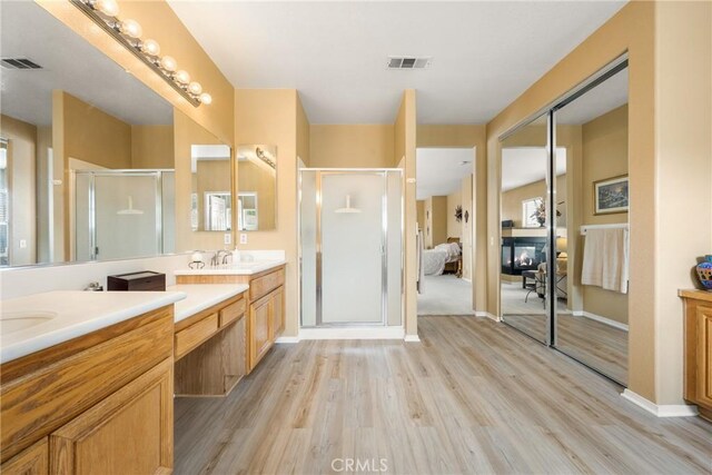 833 W Orange Heights Ln, Corona, CA 92882 - bathroom featuring double vanity, wood finished floors, and a stall shower