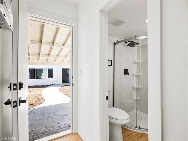 full bath with wood finished floors, toilet, and a shower stall