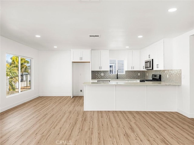 kitchen with light countertops, plenty of natural light, stainless steel appliances, and visible vents