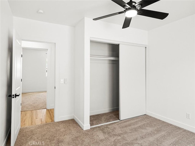 unfurnished bedroom with carpet floors, baseboards, a closet, and ceiling fan