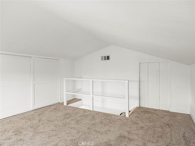 bonus room with carpet floors, lofted ceiling, and visible vents