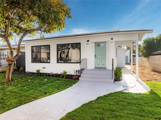 view of front of home featuring fence and a front lawn