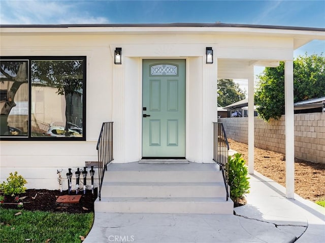 view of exterior entry featuring fence