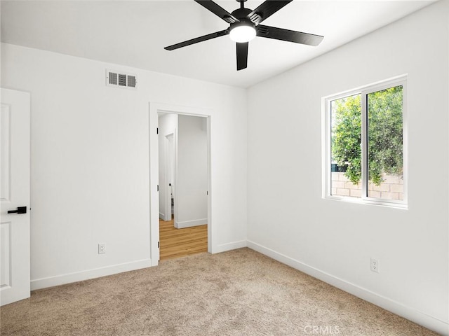 unfurnished bedroom featuring a ceiling fan, baseboards, visible vents, and carpet