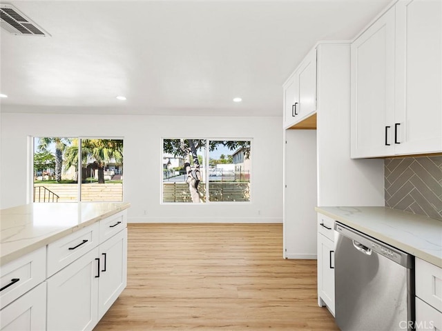 kitchen with visible vents, light stone countertops, light wood-style floors, tasteful backsplash, and dishwasher