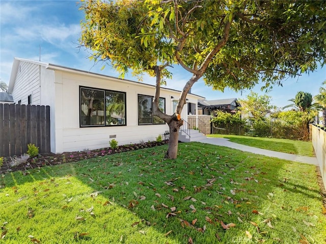 view of front facade with fence and a front yard