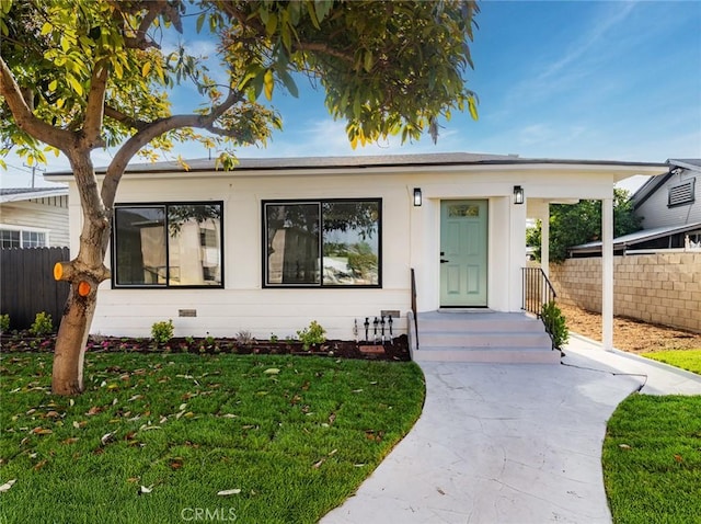 bungalow-style house featuring a front lawn, fence, and crawl space