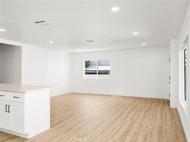 empty room featuring visible vents, recessed lighting, light wood finished floors, and baseboards