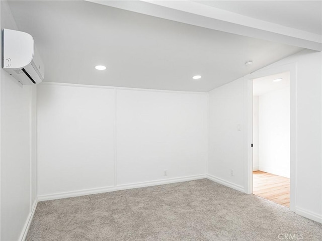 below grade area with recessed lighting, baseboards, a wall unit AC, and carpet