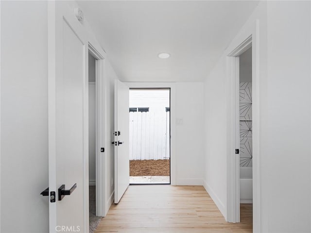 hallway featuring light wood-style floors, recessed lighting, and baseboards