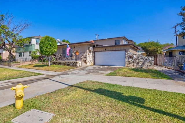 view of front of property featuring a front lawn, fence, stone siding, and an attached garage