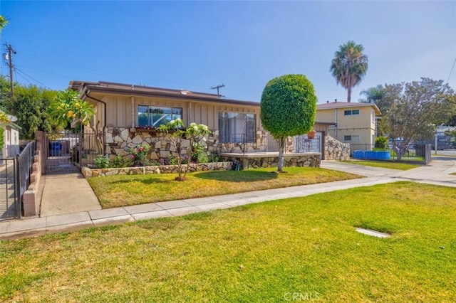 ranch-style house featuring fence, a front lawn, and board and batten siding