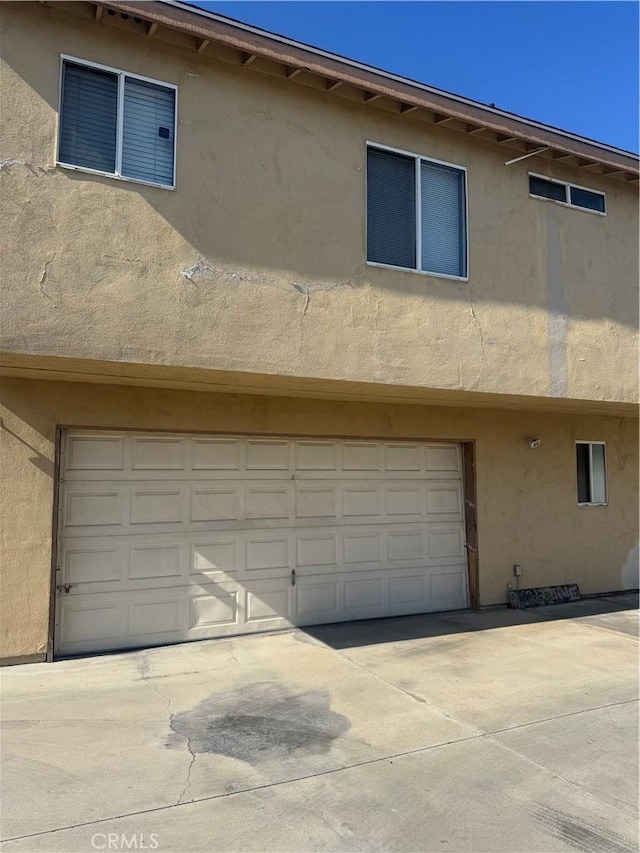 4302 Howard Ave Unit 5, Los Alamitos, CA 90720 - view of side of property with an attached garage, stucco siding, and driveway