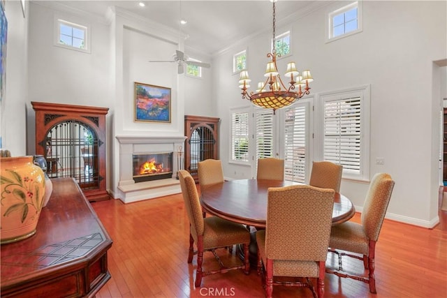 1925 Katie Ct, Fallbrook, CA 92028 - dining room with hardwood / wood-style flooring, crown molding, a chandelier, a glass covered fireplace, and healthy amount of natural light