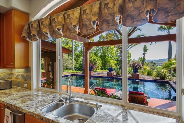 1925 Katie Ct, Fallbrook, CA 92028 - kitchen featuring a sink, light stone counters, tasteful backsplash, and brown cabinets