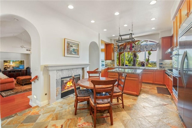 1925 Katie Ct, Fallbrook, CA 92028 - kitchen featuring arched walkways, recessed lighting, ceiling fan, a fireplace, and brown cabinets