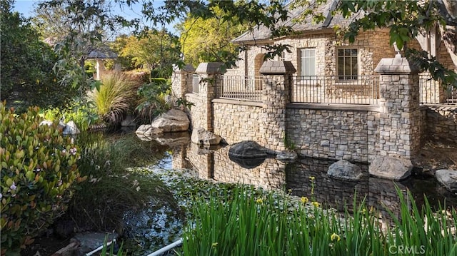 details with stone siding and a small pond