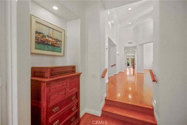 hallway with baseboards, recessed lighting, and light wood-style flooring