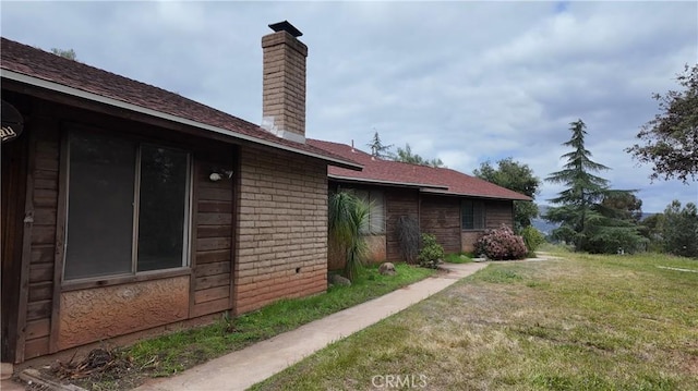 view of property exterior with a yard and a chimney