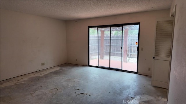 spare room featuring a textured ceiling and concrete floors