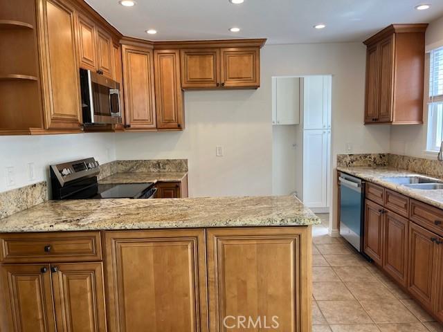 14675 Red Hill Ave, Tustin, CA 92780 - kitchen with open shelves, a sink, appliances with stainless steel finishes, and brown cabinets