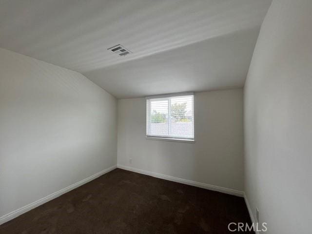 14675 Red Hill Ave, Tustin, CA 92780 - empty room with visible vents, baseboards, lofted ceiling, and dark colored carpet
