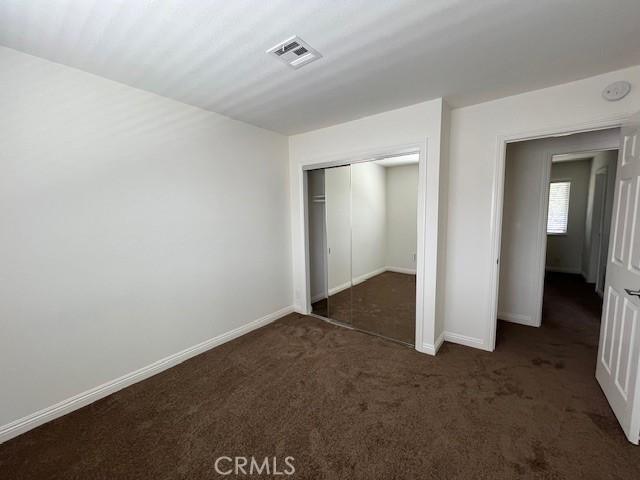 14675 Red Hill Ave, Tustin, CA 92780 - unfurnished bedroom with baseboards, visible vents, carpet, and a closet